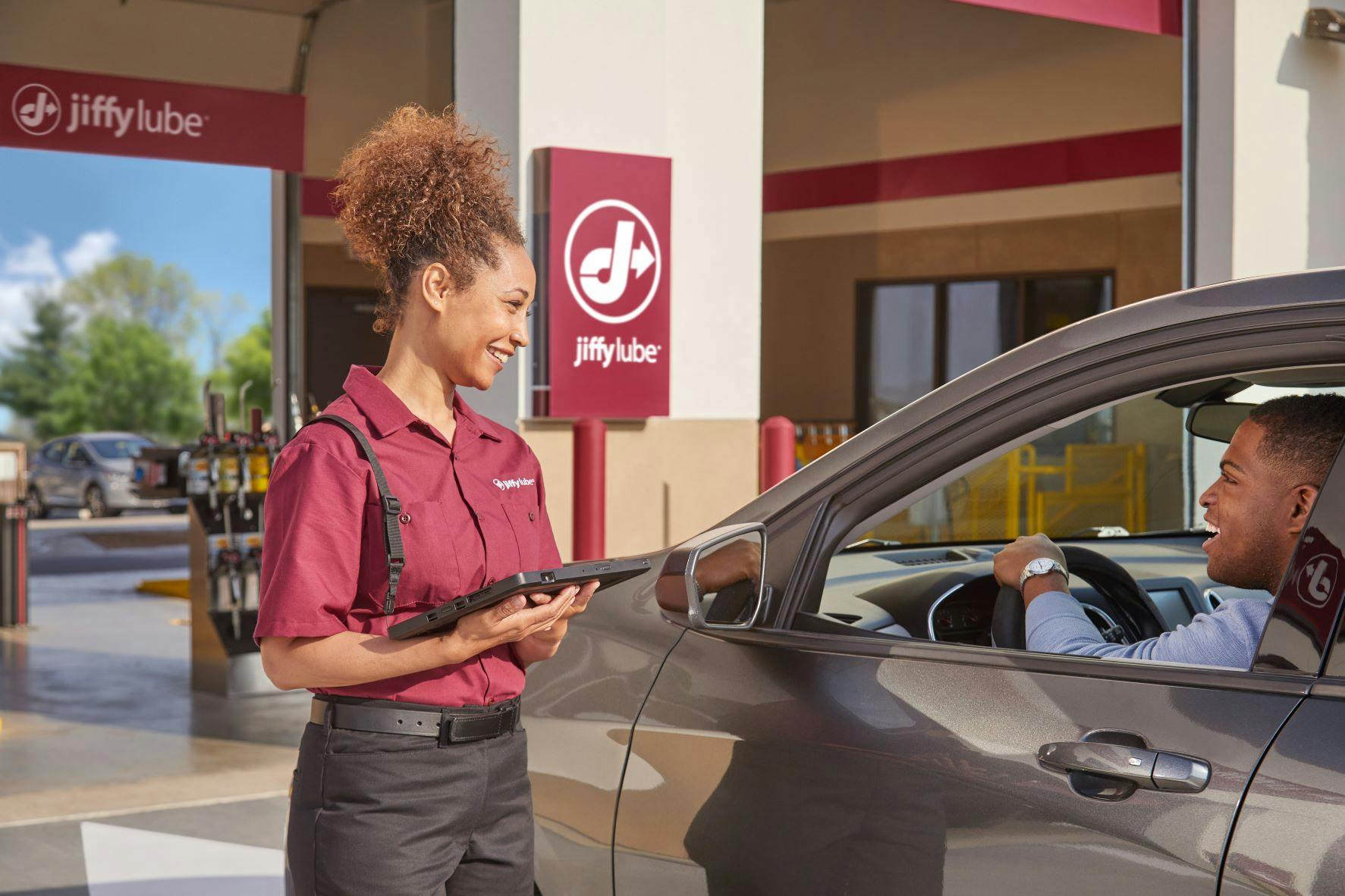 Jiffy Lube technician greeting a customer as they come in to get their serpentine belt replaced 